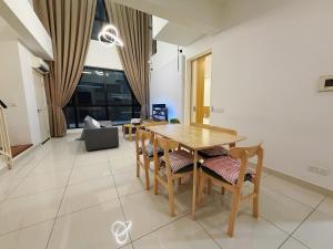 ein Esszimmer mit einem Holztisch und Stühlen in der Unterkunft Econest Eco Botanic Muji Style Duplex 3BR Educity in Iskandar Puteri