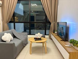 Una sala de estar con un sofá y una mesa de café. en Econest Eco Botanic Muji Style Duplex 3BR Educity, en Iskandar Puteri