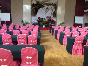 uma fileira de cadeiras em uma sala com assentos rosa em San Jiang Grand Hotel em Ban Vat Tay mais 184 fotografias