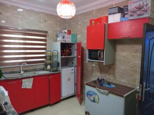 a kitchen with red cabinets and a white refrigerator at Reme's APARTMENT in Mama