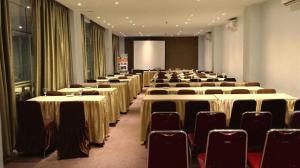 a row of tables and chairs in a room at Grand Hawaii Hotel Pekanbaru in Pekanbaru