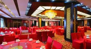 uma sala de jantar com mesas vermelhas e cadeiras vermelhas em Baodao Exhibition Center Hotel em Wuyishan