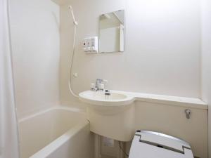 Un baño blanco con lavabo y espejo. en Comfort Inn Niigata Kameda, en Niigata