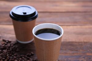 Dos tazas de café sobre una mesa con granos de café. en Comfort Inn Niigata Kameda, en Niigata