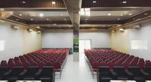 una stanza vuota con sedie rosse in un edificio di Flamengo Hotel a Gedeg