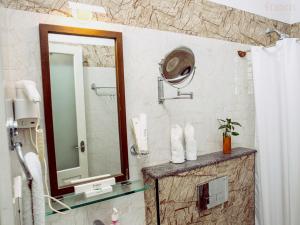 a bathroom with a shower with a mirror and a sink at The Francis Residence in Cochin