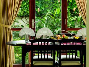 uma mesa com cadeiras e frutas numa varanda em The Francis Residence em Cochin