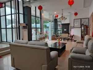 Uma sala de estar ampla com sofás, mesa e janelas. em Queen City Hotel em Bugis