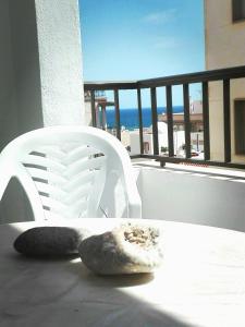 una silla blanca en el balcón con vistas al océano en Casa Paqui, en Carboneras