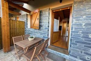 un patio con una mesa de madera y 2 sillas en La caseta dels jardins, en Osséja 7 fotos más
