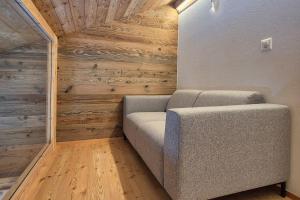 布里特泽根Stadel Alpenstern mit Wellnessbereich的木墙的房间里一张沙发 更多13张照片