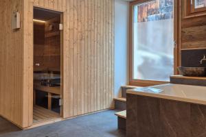 布里特泽根Stadel Alpenstern mit Wellnessbereich的配有木制橱柜和水槽的厨房