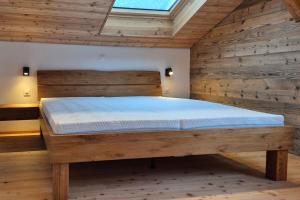 布里特泽根Stadel Alpenstern mit Wellnessbereich的带木墙的房间里的一张床