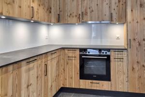 布里特泽根Stadel Alpenstern mit Wellnessbereich的厨房配有木制橱柜和炉灶。