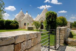 ein Haus mit einer Steinmauer und einem Tor in der Unterkunft Abate Masseria & Resort in Noci