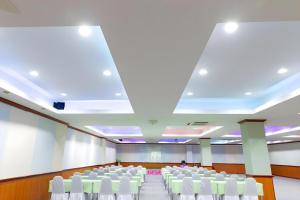 a conference room with white chairs and a large ceiling at Rimnam Hotel Suk Sawat 70 in Ban Khru Nok