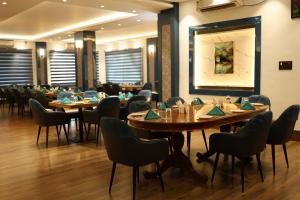 a dining room with wooden tables and chairs at Dibang Hotel & Resort in Mekha