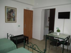 um quarto com uma mesa e uma sala de jantar em Fatamorganamessina em Messina