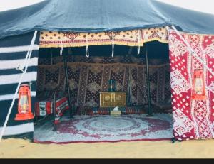 Un cenador con un sofá y una mesa. en EXPIORER Desert Camp, en Al Raka