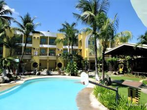 um resort com piscina em frente a um prédio em Country Village Hotel em Carmen