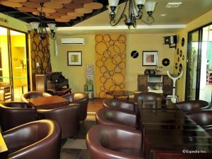 um restaurante com cadeiras de couro castanho e um bar em Country Village Hotel em Carmen