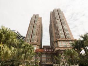two tall buildings with palm trees in front of them at The Bauhinia in Shenzhen