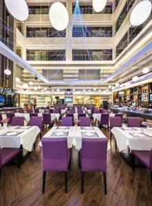 a restaurant with purple and white tables and chairs at The Bauhinia in Shenzhen