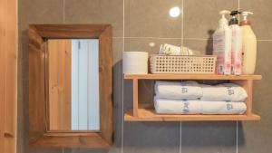 a bathroom with a shelf with towels and a mirror at Hello jeje Guesthouse in Jeonju +48 photos