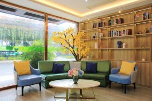 a living room with a couch and two chairs and a table at Vatica Fuzhou West Second Ring Road Xihu Park Hotel in Fuzhou