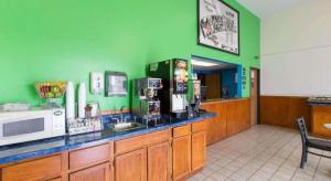 a restaurant with green walls and a counter with a microwave at Super 8 By Wyndham Wayne in Wayne