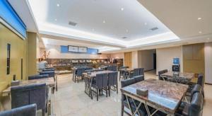 um restaurante com mesas e cadeiras em uma sala em Lavande Hotels Harbin Shimao Avenue Wanda em Harbin