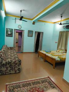 uma sala de estar com duas camas e um sofá em KHS villa em Ambāsamudram