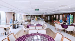 um restaurante com mesas e cadeiras roxas e mesas e cadeiras em Khach san Toan Thang Stone em Lóc Ða