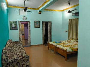 um quarto com uma cama, um sofá e um relógio em KHS villa em Ambāsamudram mais 3 fotografias