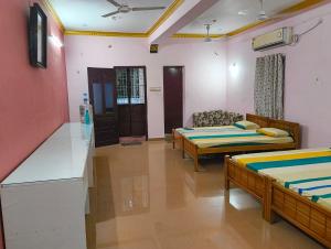 um quarto com duas camas e um sofá em KHS villa em Ambāsamudram