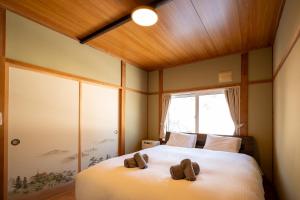 una camera da letto con un letto con due scarpe marroni sopra di 緑の夢の家 a Furano