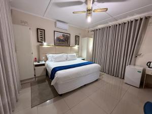 a bedroom with a large white bed and curtains at Villa Thabiso in Bulawayo +36 photos