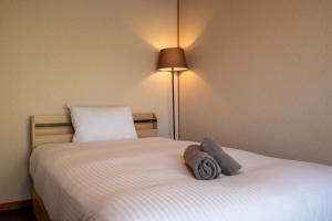 una camera da letto con un letto con due asciugamani sopra di 緑の夢の家 a Furano Altre 23 foto