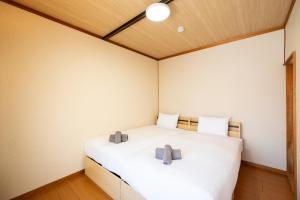 una camera da letto con un letto bianco con due cuscini sopra di 緑の夢の家 a Furano