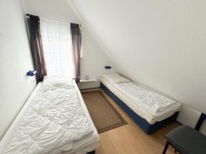 two beds in a small room with a window at Ferienwohnung Sonnenperle - Wohnung 13 in Breege