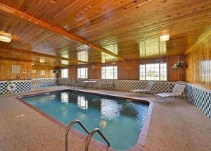 a large swimming pool in a building with a wooden ceiling at Quality Inn & Suites Grinnell near University in Grinnell