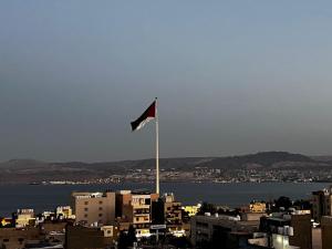a red and white flag on top of a city at Old Town Hotel in Aqaba