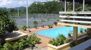 uma vista para uma piscina com árvores e uma cerca em Insel Fehmarn Hotel em Apia mais 41 fotografias