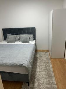 a bedroom with a bed and a white wall at Holiday House Maya in Mostar +36 photos