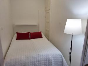 a bedroom with a bed with red pillows and a lamp at Luxhousing apartment with balcony in Helsinki