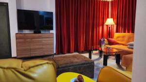 a living room with red curtains and a tv at Villa Whitney in Lamai