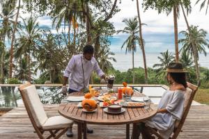 Un hombre y una mujer sentados a una mesa con una comida en Walatta House, en Tangalle