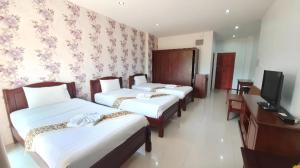 a hotel room with three beds and a television at Doungta Anda Hotel Krabi in Ban Khlong Chi Lat