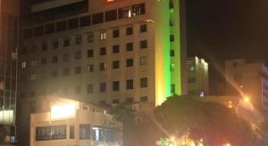 a building with a green light on the side of it at Super 8 Hotel Quanzhou Xinchezhan Branch in Quanzhou