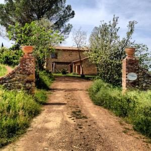 a dirt road in front of a brick building at Villa Berti in Montescudaio